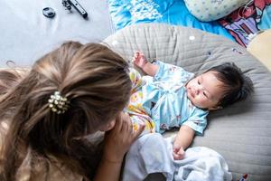 asiatisches neugeborenes baby kind blickkontakt mit mutter niedlichkeit von kindern mit glücklicher familie auf weicher matratze metapher lebendes leben gesunder lebensstil süß von kind baby produkte gesundheitsprodukte für mutter und baby foto