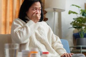 asiatische frau erkrankt zu hause an grippe und husten foto
