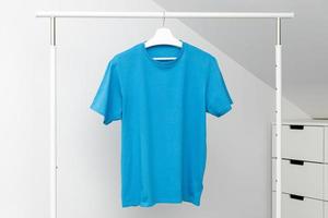 T-Shirt hängt am Kleiderständer. Rundhalsausschnitt blaue Farbe. Vorlage, Mockup foto