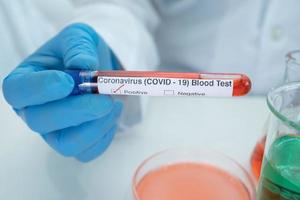 Positive Blutinfektionsprobe im Reagenzglas für Covid-19-Coronavirus im Labor. Wissenschaftler halten, um Patienten im Krankenhaus zu überprüfen und zu analysieren. foto