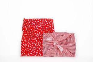 Geschenke eingewickelt in rotes Feiertags-Furoshiki-Geschenktuch foto