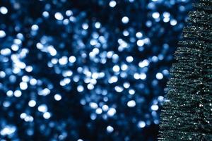 grüner Glitter-Weihnachtsbaum auf blauem Paillettenhintergrund foto