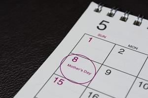 Mai-Kalender auf dunklem Hintergrund mit Datumskreis für den glücklichen Muttertag. foto