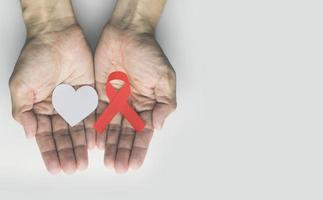 Mann mit rotem Aids-Band, Alterungsbewusstseinsmonatskonzept foto
