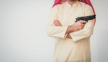 arabischer mann, der mit hand hält waffe steht foto