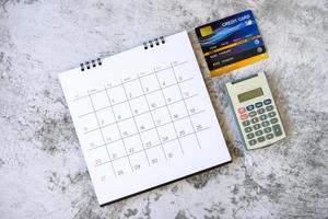 Kalender mit Tagen und Kreditkarte auf dem Tisch. Einkaufskonzept foto