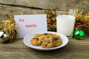 Kekse und ein Glas Milch mit einer weißen Note für Santa foto