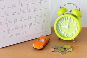 Kalender und Auto auf dem Tisch. Tag des Kaufs oder Verkaufs eines Autos oder Zahlung für Miete, Darlehen oder Reparatur foto