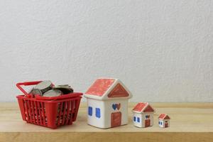 Münzen in einem Korb rot und Hausmodell für Geldkonzept foto