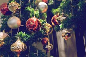 Kugel, die an einem geschmückten Weihnachtsbaum hängt. Unschärfe und Retro-Filtereffekt. foto