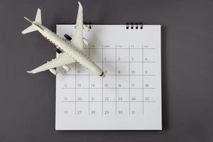 Flugzeugmodell mit Papierkalender. Reise planen foto