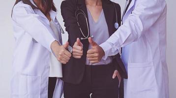 ärzte und krankenschwestern koordinieren hände. ärzte daumen hoch, konzept teamwork foto