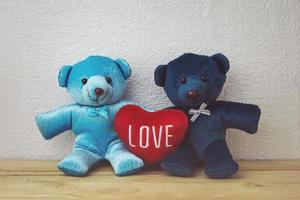 Schöner Teddybär und rote Herzform, die auf einem Holztisch sitzen