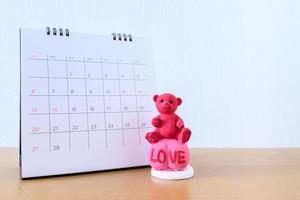 Teddybär vor dem Kalender. konzept für den hochzeitsvalentinstag. foto