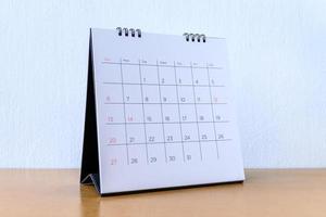 generischer Kalender mit Tagen auf Holztisch foto