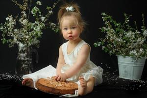 kleines Mädchen feiert ihren ersten Geburtstag. Mädchen isst ihren ersten Kuchen. foto