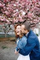 Verliebtes Paar in einem blühenden Apfelgarten, der auf der Decke liegt foto