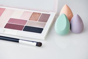 Make-up-Mixer-Schwämme und Lidschatten-Palette auf weißem Hintergrund foto