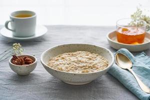 ganze Haferflocken, große Schüssel Haferbrei mit Butter zum Frühstück, Morgenmahlzeit. Seitenansicht foto