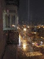 Foto von Regentropfen auf Glas vor dem Hintergrund einer nächtlichen Stadt