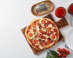 heiße hausgemachte italienische Peperoni-Pizza mit Salami, Mozzarella auf weißem Tisch foto