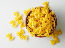 Pasta Farfalle in Holzschale auf grauem Steintisch. Draufsicht, Nahaufnahme. foto