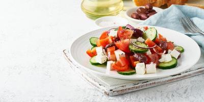 Griechischer Dorfsalat Horiatiki mit Schafskäse, Oliven, Kirschtomaten, Gurken und roten Zwiebeln foto