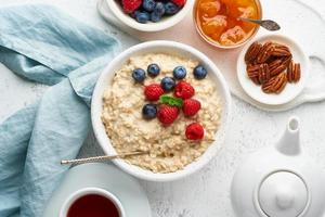 haferbrei mit blaubeeren, himbeeren, marmelade und nüssen, draufsicht. Frühstück mit Beeren foto