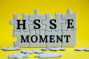 HSSE-Moment-Text auf Puzzle mit gelbem Hintergrund - Gesundheit, Sicherheit, Schutz und Umwelt. foto