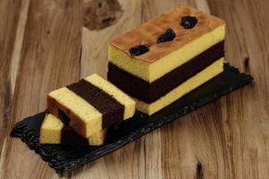 Spiku oder Lapis Surabaya, indonesischer Dreischichtkuchen mit Erdbeermarmelade zwischen den Schichten. mit Pflaumen belegt foto