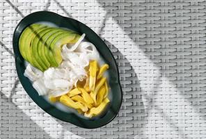 es campur, indonesische Fruchtcocktailsuppe mit Avocado, zerkleinertem jungem Kokosnussfleisch, Jackfrucht und einfachem Sirup foto