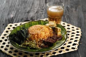 Nasi Padang oder Padang Reis ist ein berühmtes traditionelles Essen aus Indonesien. Reis mit Rendang vom Rind, Maniokblättern und grüner Chilipaste. foto
