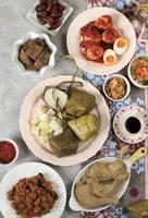 Ketupat Lebaran. Traditionelles festliches Gericht aus Reiskuchen oder Ketupat mit verschiedenen Beilagen, das während der Eid-Feierlichkeiten sehr beliebt ist foto