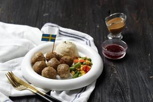 schwedisches fleischbällchen mit brauner pilzsoße und gekochtem gemüse, serviert mit cremigem kartoffelpüree. foto