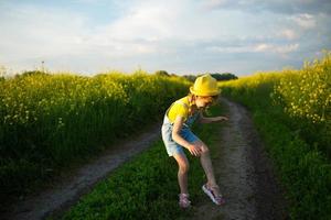 Mädchen in einem Feld tötet Mücken, die ihre Hände und Füße beißen. das Kind schlägt sich auf den Körper, Schutz vor Insektenstichen, Repellent sicher für Kinder. Erholung im Freien, gegen Allergien foto