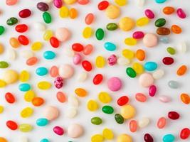 viele verstreute bunte Bonbons, Bonbons, Lutscher auf weißem Hintergrund, Draufsicht. Gummibärchen. foto