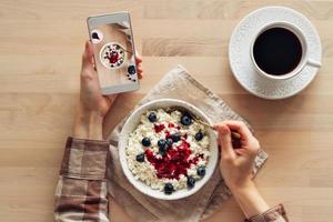 Blogger fotografiert Essen, fotografiert Frühstück auf dem Handy, foto