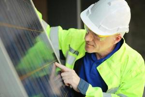 Sonnenkollektoren auf einem ländlichen Hügel an einem hellen, sonnigen Tag, der den Anwohnern eine nachhaltige erneuerbare Energiequelle bietet foto