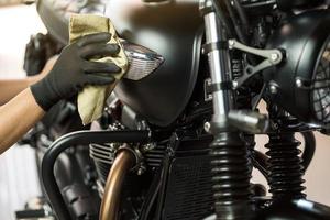 biker mann motorrad reinigen, wachs auf kraftstofftank polieren und beschichten. reparatur- und wartungsmotorradkonzept. foto