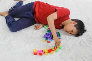 Trauriges und gelangweiltes autistisches Kind, weil es allein mit Spielzeug spielt. traumatische Erfahrung in der Kindheit, Psychologie, psychisch, Asperger-Syndrom, Asperger-Störung, Autismus, Autismus. foto