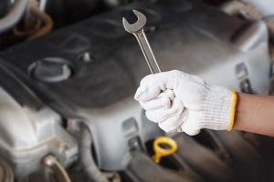 Hand des Automechanikers mit Schraubenschlüssel foto