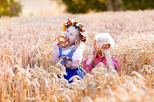Kinder in bayerischen Kostümen im Weizenfeld foto