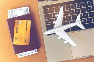 Flugtickets, Pässe und Kreditkarten in der Nähe von Laptop-Computer und Flugzeug auf dem Tisch. Online-Ticket-Buchungskonzept foto