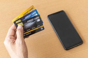 Mann mit Kreditkarten und Smartphone. Online-Shopping im Internet mit einem Smartphone foto