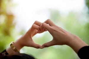 Die Hand eines Mädchens, das eine Herzform macht, zeigt Liebe foto