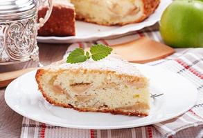 Stück Apfelfruchtkuchen auf einem mit Minzblatt dekorierten Teller foto