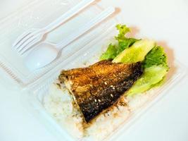 Fisch auf Reis in Plastikbox grillen, Essen mit nach Hause nehmen foto