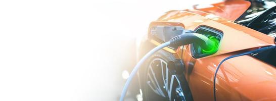 elektro ev auto orange batterie energie in der station aufladen. Panorama-Webbanner auf weißem Hintergrund mit Kopierraumkonzept. foto