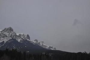 schneebedeckte felsige berge mit dunstigem grauem himmel foto