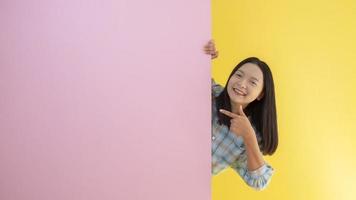 glückliches junges Mädchen des Studenten mit rosa und gelbem Hintergrund. foto